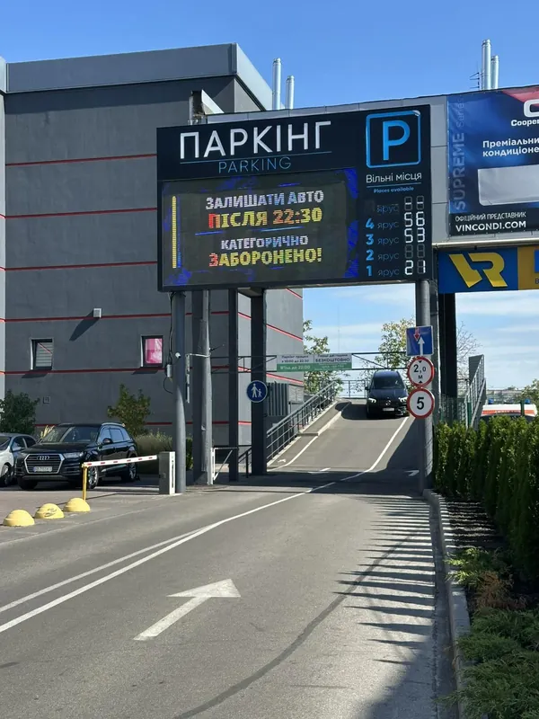В'їзд на критий паркінг: табло «Паркінг», шлагбаум і рампа